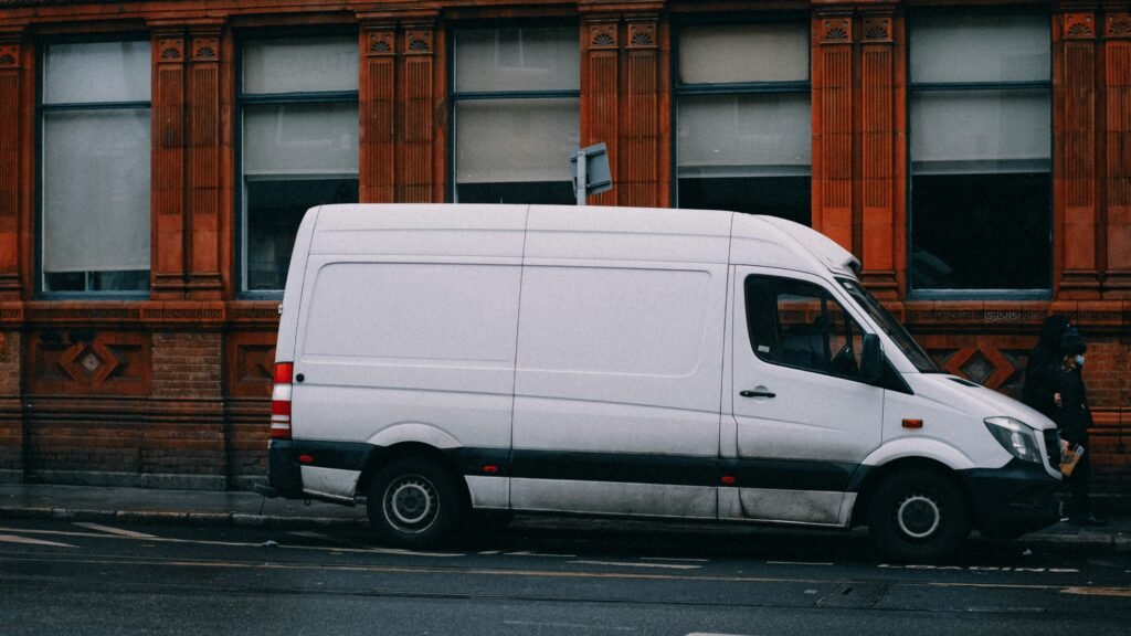 White van parked in front of a wall